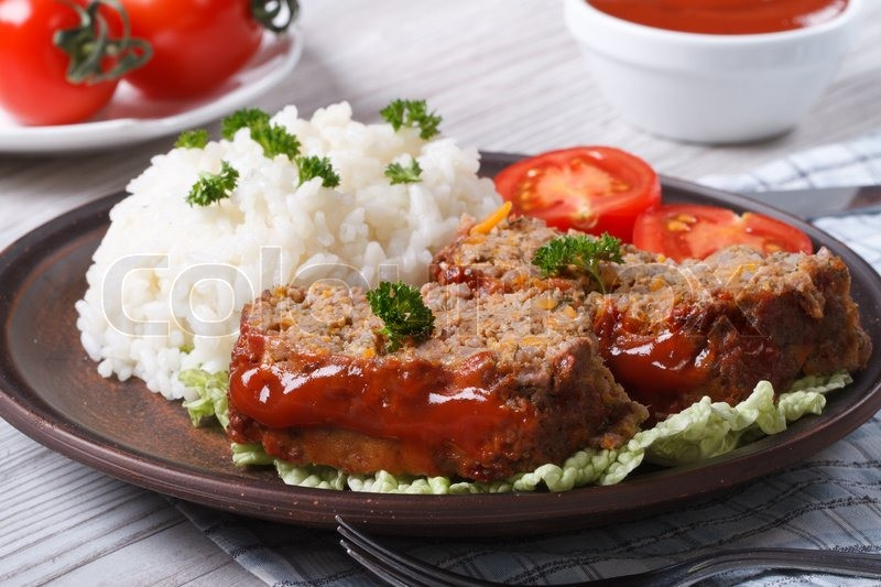 Meatloaf With Rice
 Sliced meat loaf with rice and ve ables on a plate close